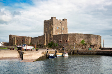 View to medieval norman Carrickfergus castle across the harbour in Northern Ireland. - obrazy, fototapety, plakaty