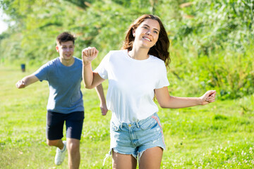 Obraz premium Cheerful teenagers are jogging together in the park and having fun