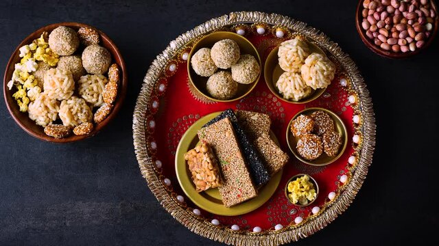 Til chikki peanut chkki woman hand take Murmura ladoo til laddu Revdi popcorn Indian festival snack sweet Lohri Makar Sankranti Pongal Diwali 4K video footage winter food Tamil Nadu Punjab India