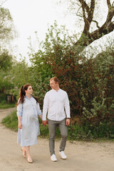 Fototapeta premium Young heterosexual pregnant couple in an outdoor park