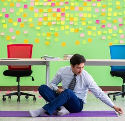Man in the office with many conflicting priorities doing exercis