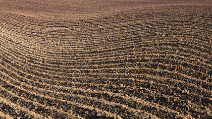 Plowed field with deep furrows, beautiful textured background