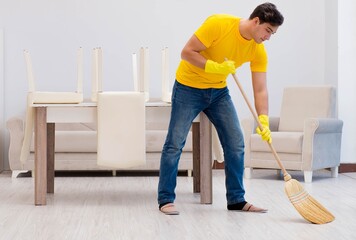 Man husband cleaning the house helping his wife