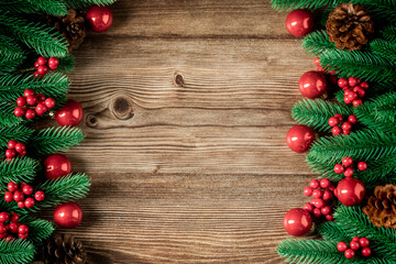 Top view of green branches, pine cones, Christmas stars, red balls, red berries on dark wooden background, Banner, copy space, Christmas or New Year background concept.
