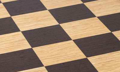 Chessboard texture with dark and light cells, selective focus, close-up.