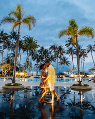 Palm trees and swimming pool of luxury resort in Asia. palm trees during sunset. couple man and...