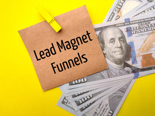 Banknotes and brown card with text Lead Magnet Funnels on a yellow background.
