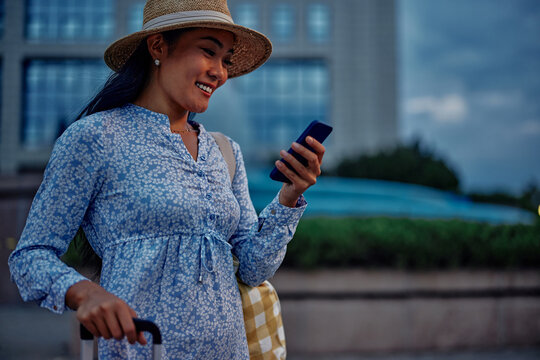 Young woman using phone while traveling in a foreign city