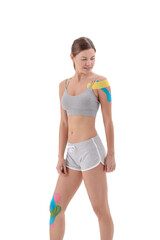 Fototapeta na wymiar Physio tapes applied to the body of a young athletic woman isolated on white. Physiotherapy, kinesio taping, kinesiology and recovery treatment concepts.