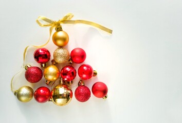 Christmas balls in the shape of a pyramid. New Year background. Red and gold Christmas balls on a white background with a place for text. Banner, Christmas card