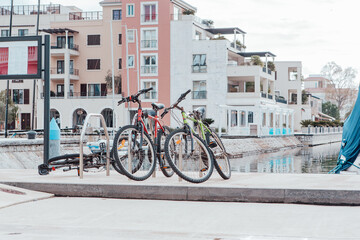Fototapeta premium Bicycles are parked on the embankment. Bicycle parking in the background of modern houses. Urban backdrop for branding, banner, cover, card, poster, header for website. High Quality Horizontal Photo