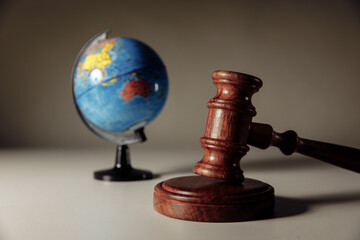 Wooden Judge gavel and globe on the desk. International law and justice court concept