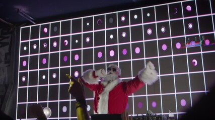 Dj Santa Claus playing funny modern music, crowd of dancing people at New Year