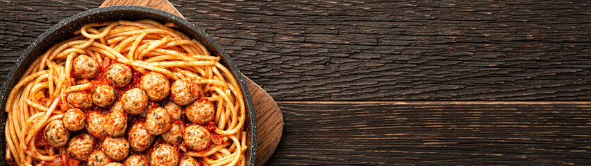 Frying pan SPAGHETTI MEATBALLS Like an Italian on wooden background with copy space banner