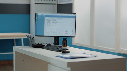 Close up of computer with medical files on monitor in cabinet. Nobody in doctors office with equipment, instruments and documents for healthcare examination and checkup appointment