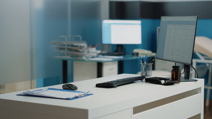 Nobody in doctors office with medical equipment and tools. Empty cabinet with computer, healthcare instruments, checkup documents and papers on desk. Office for consultation at facility