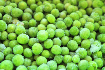 Frozen green peas, vegetables background