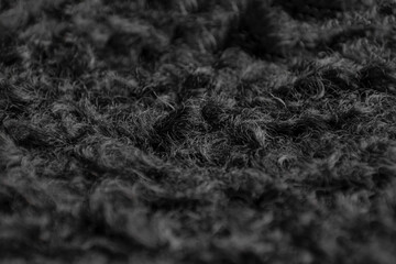 close-up of curly fur. black faux fur. eco lamb wool. black wool