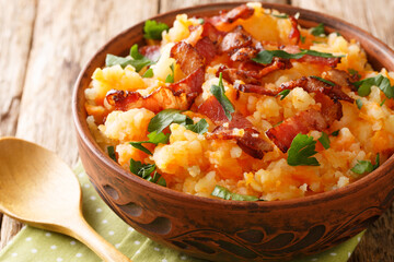 Mashed potatoes and carrots with bacon close-up in a bowl on the table. horizontal