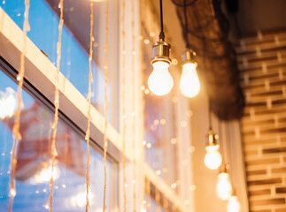 Garland and light bulbs on the window. Festive atmosphere. Blurred lights.