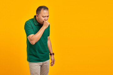 Portrait of Handsome Man feeling unwell and coughing on yellow background