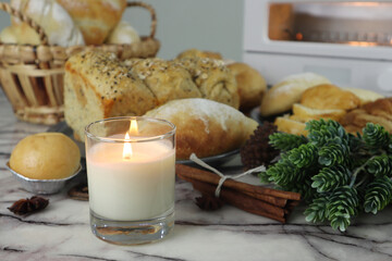 scented candle is on the white marble table with homemade toast breads, toaster oven, cinnamon...