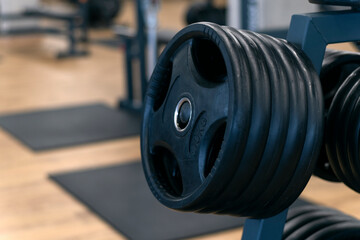 Obraz premium Black dumbbells for barbells. Equipment for weight gain. Sports equipment. Different weights for the barbell.