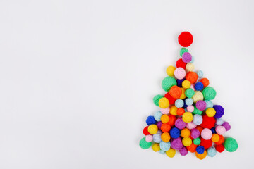 Creative Christmas tree made of multicolored wool balls for knitting on a white background.Christmas card layout for knitting lovers, New Year discounts on knitting training, online courses