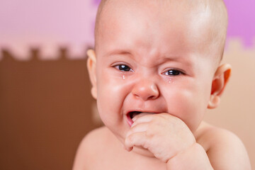 Crying newborn put his hand in his mouth