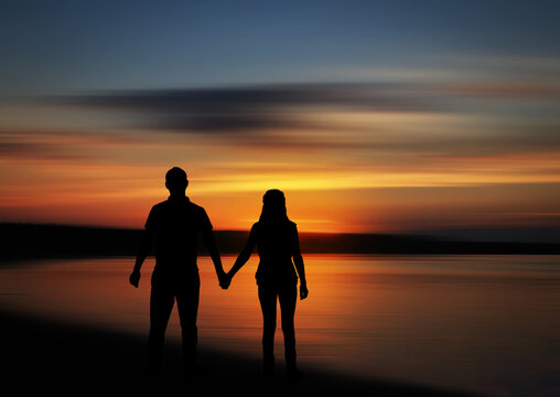 Sunset silhouette of couple on beach