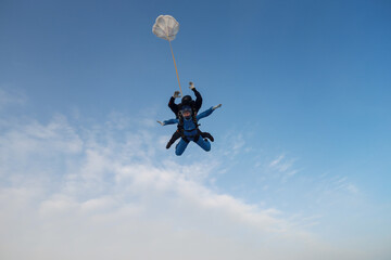 Fototapeta na wymiar Skydiving. Tandem jump. An instructor and a girl are in the sky.