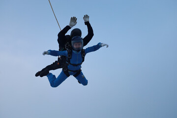 Skydiving. Tandem jump. An instructor and a girl are in the sky.