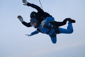 Skydiving. Tandem jump. An instructor and a girl are in the sky.
