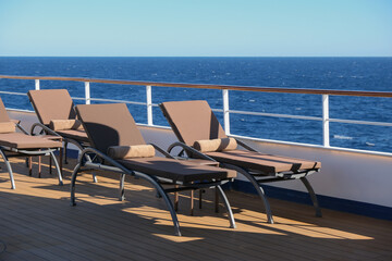Padded Sun loungers on outdoor deck of luxury yacht cruiseship cruise ship liner with ocean views