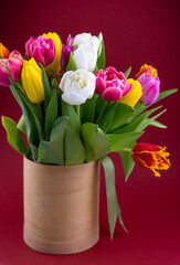 Mix of spring tulips flowers. Bouquet in a vase. Multi-colored spring flower. Gift. Red, pink, white and yellow. Background with flowers tulips close-up different colors