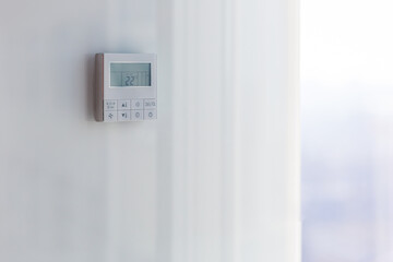 The air conditioning and heating control panel for the apartment and office is located on a white wall