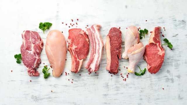 Banner. Raw meat steaks salmon, beef and chicken on a white wooden background. Organic food. Top view.
