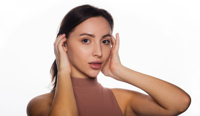 Beautiful face of young woman with clean fresh skin standing in short turtleneck. Beauty portrait of brunette standing on white background copy space