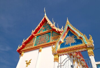 Naklejka premium Thai temple soars into blue sky