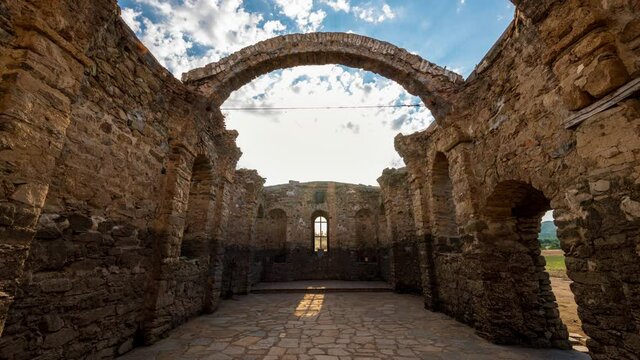 Time lapse with moving clouds between the ruins of the ancient medieval eastern orthodox church of Saint John of Rila at the bottom of Zhrebchevo Dam, Sliven Region, Bulgaria