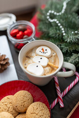 Fototapeta na wymiar christmas, winter holidays and leisure concept - close up of marshmallow snowman in cup of coffee