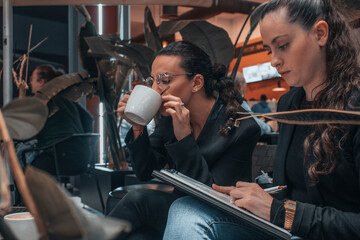 Equipo de abogadas con seriedad escribiendo planteamientos en sus notas junto con sus ordenadores de trabajo mientras toman cafe en una cafeteria de un centro comercial 