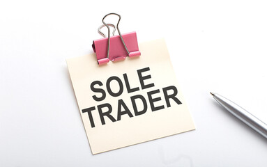 SOLE TRADER text on the sticker with pen on white background