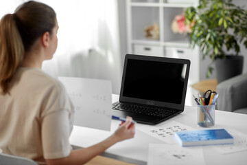 distant education, school and people concept - female math teacher with laptop computer and mathematics having online class at home