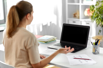 distant education, remote job and people concept - happy smiling female teacher with laptop computer having video call or online class at home office
