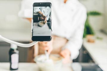 Food blogger showing process of making cakes online.