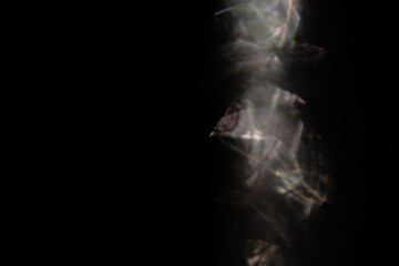 Blurred golden retro film lens flare bokeh on black background. Crystal light leaks, Defocused abstract multicolored analog photo overlay or screen filter effect. Glow Vintage prism warm colors