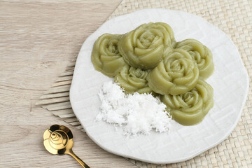 Kue Lumpang Pandan or Kue IJo, Indonesian traditional food with springy texture, made from sago flour and rice flour, sugar and pandan. Served in white plate, selective focus image.
