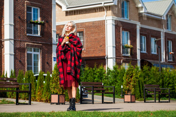 Full body portrait of young blonde woman in red blanket