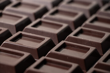 Close up a chocolate bar background. Chocolate bar cubes macro